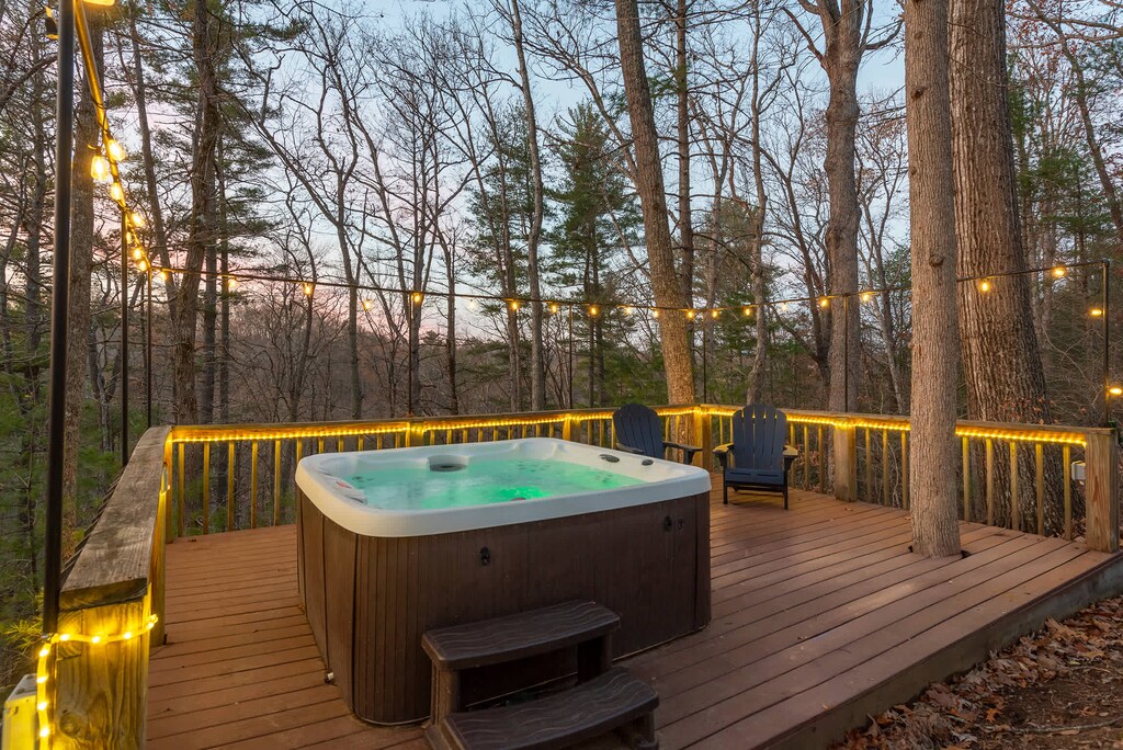 Your private forest retreat: a hot tub oasis illuminated by enchanting string lights.