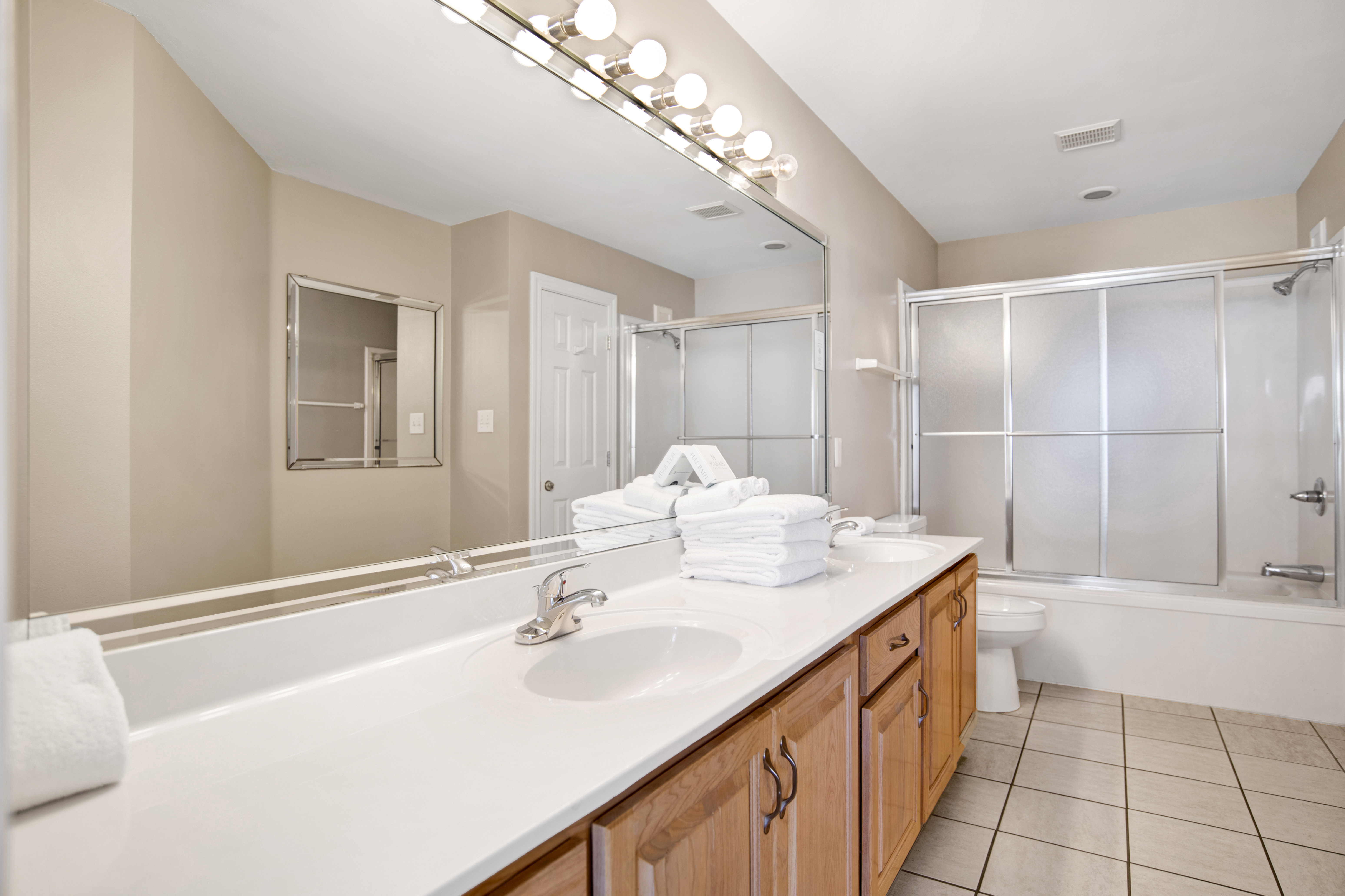 Private bathroom has double vanities and a large tub/shower combo