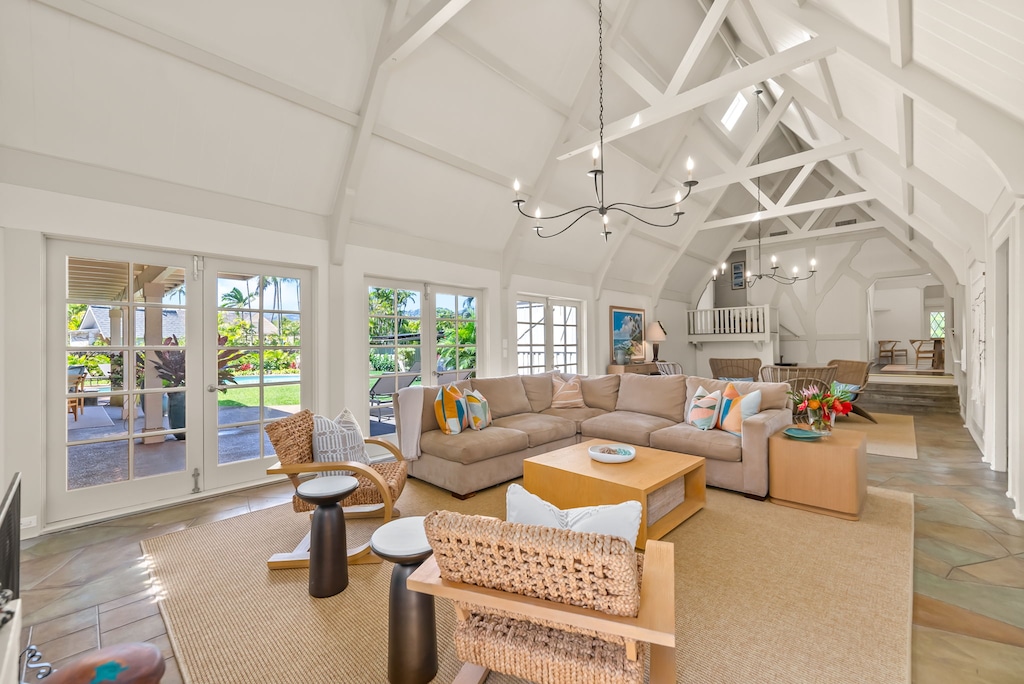 A cozy and spacious living room with vaulted ceilings, plush seating, and abundant natural light, ideal for relaxing with family and friends.