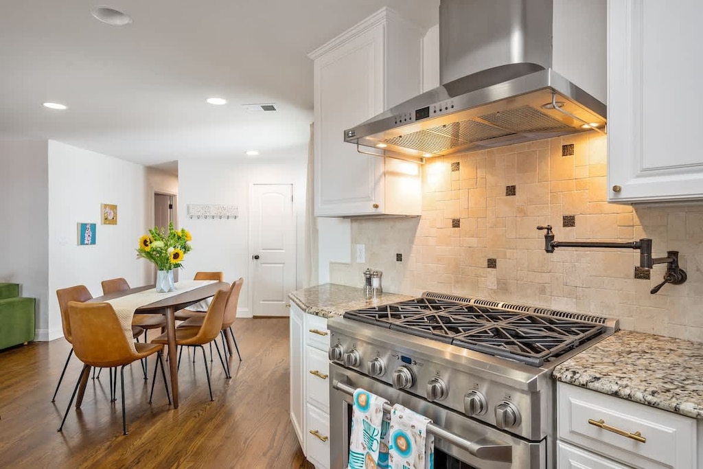 Bright, modern kitchen with a professional-grade stove, granite countertops, and a welcoming dining area—perfect for cooking and gathering with loved ones.