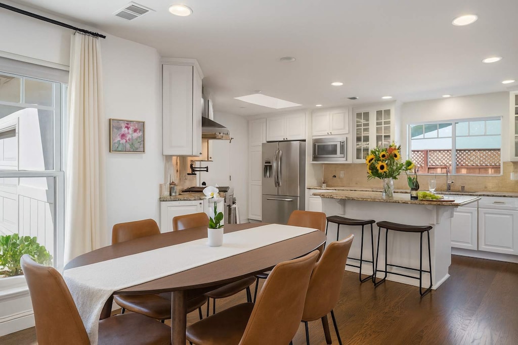 Beautifully designed dining area with a stylish kitchen, sunlit windows, and everything you need for a relaxed and enjoyable stay.