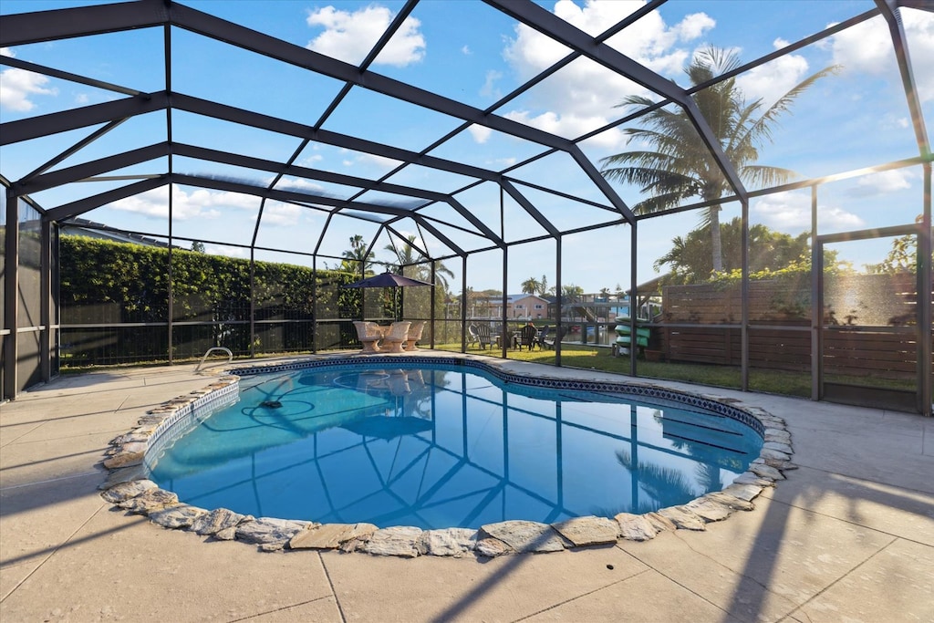 Private pool covered under a lanai with seating