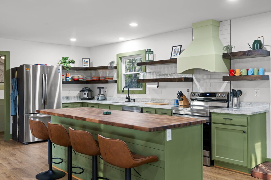 Fully stocked chef's kitchen with gorgeous green cabinetry.