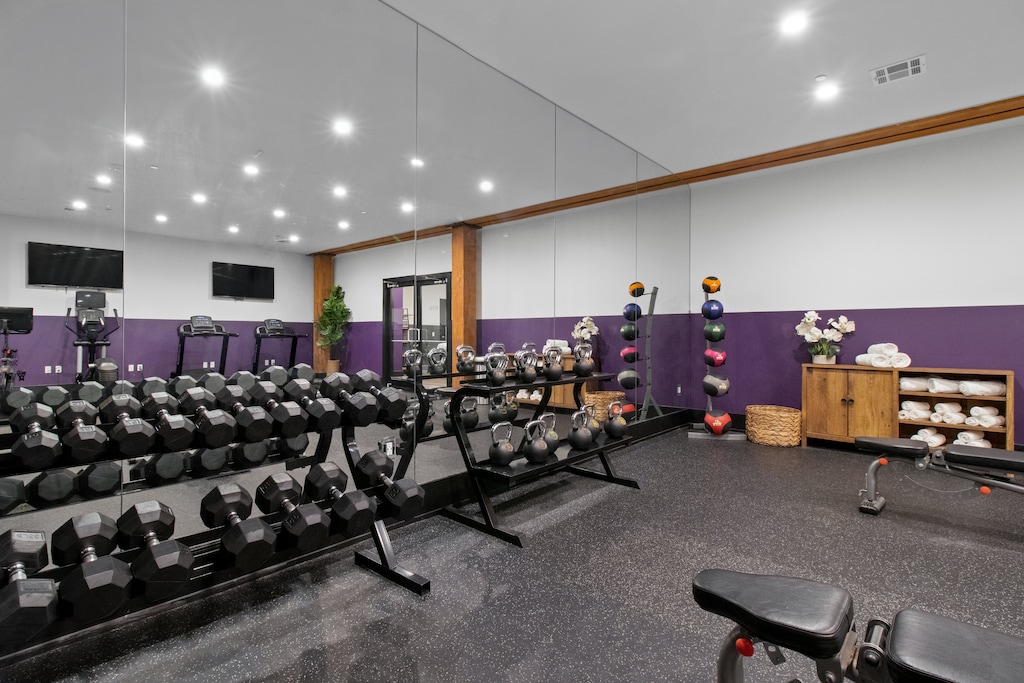 Stay fit at 888 Baronne Street with a fully equipped gym featuring Cybex machines, TRX bands, Peloton, cardio gear, free weights, smart TVs, and a filtered water station—all in a clean, modern space.