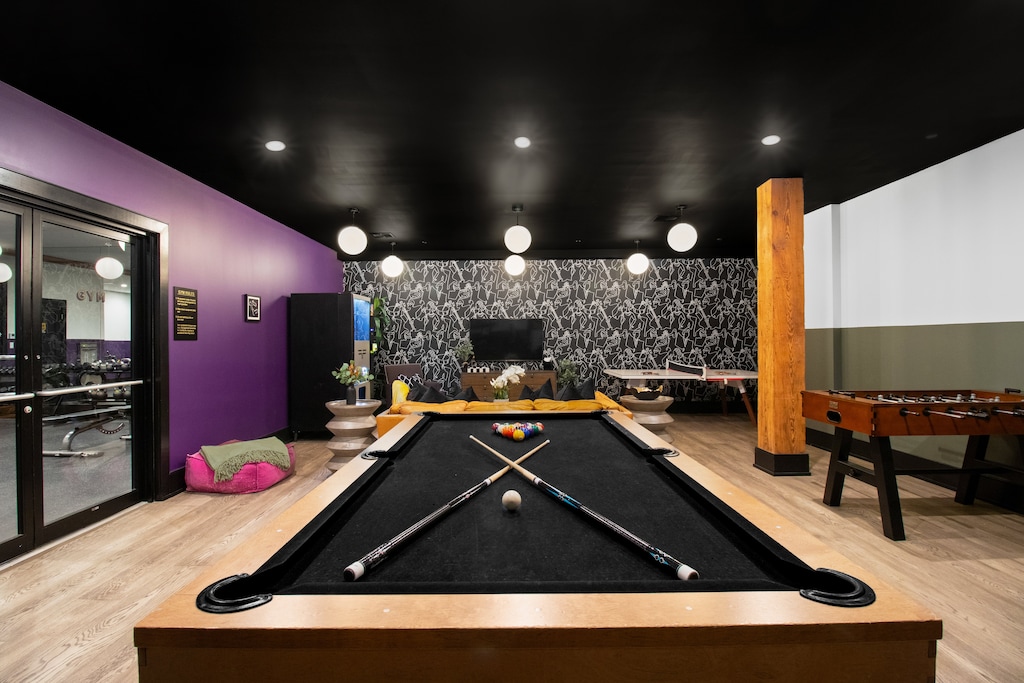 Enjoy friendly competition in 888 Baronne's guest-only game room with a pool table, ping pong, foosball, smart TV, and sofa lounge seating. Perfect for relaxing after a day in New Orleans—ideal for families, friends, and group getaways.