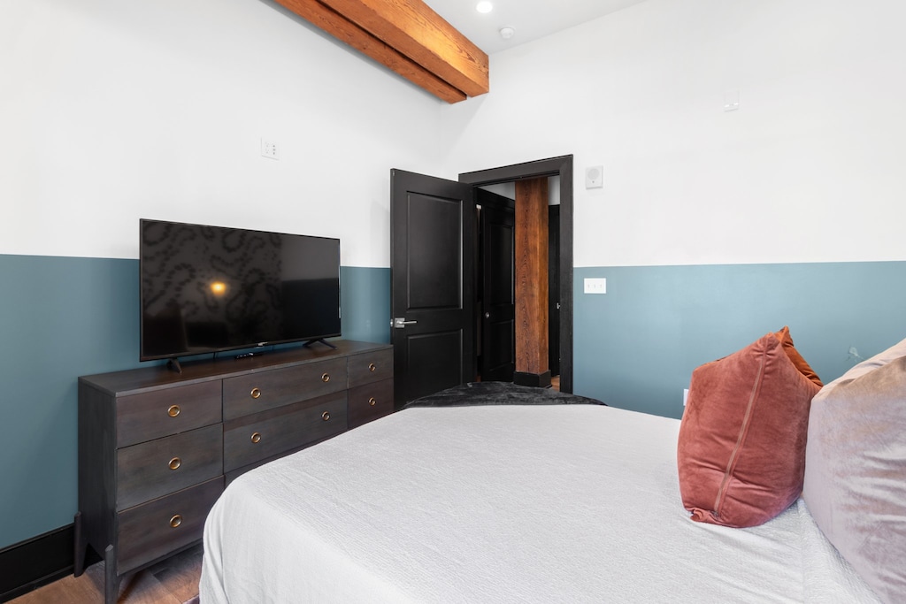 The second bedroom offers a cozy queen bed, dresser, smart TV, and soft linens. Great for families or friends traveling together, this room combines comfort and privacy in the heart of Downtown New Orleans.