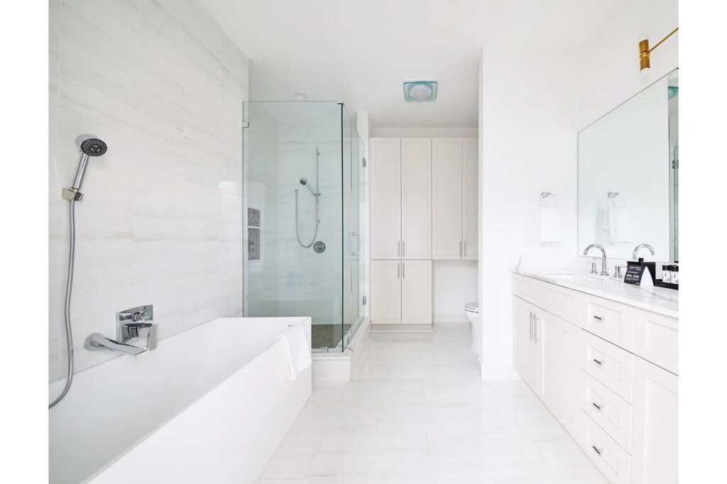 The primary bathroom offers sleek finishes, a soaking tub with Smart TV, walk-in shower, and plush towels. Spacious and private, it adds a luxurious touch to your suite—perfect for unwinding after a day in Downtown New Orleans.