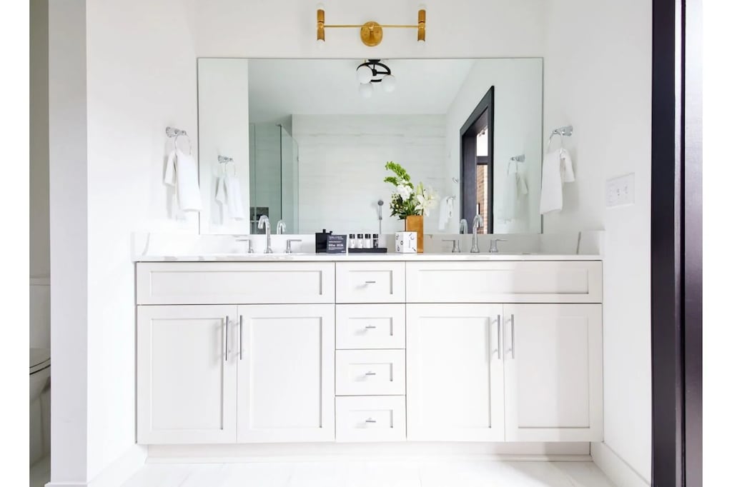 The primary bathroom offers sleek finishes, a soaking tub with Smart TV, walk-in shower, and plush towels. Spacious and private, it adds a luxurious touch to your suite—perfect for unwinding after a day in Downtown New Orleans.