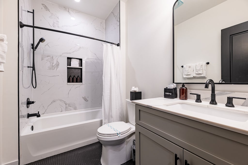 The guest bathroom includes fresh towels, a hairdryer, and complimentary toiletries. Conveniently located near the living area, it's stylish and practical—perfect for guests, families, or sharing during group stays at 888 Baronne.