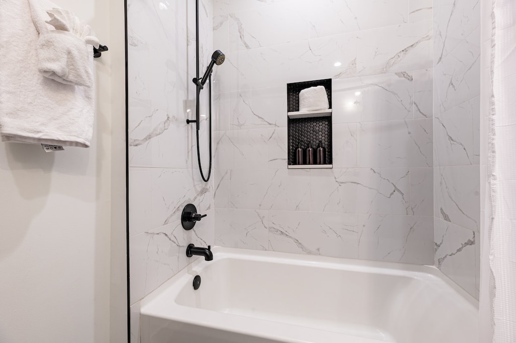 The guest bathroom includes fresh towels, a hairdryer, and complimentary toiletries. Conveniently located near the living area, it's stylish and practical—perfect for guests, families, or sharing during group stays at 888 Baronne.