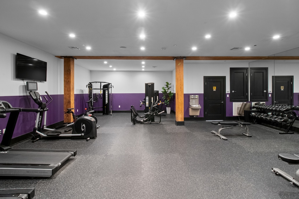 Stay fit at 888 Baronne Street with a fully equipped gym featuring Cybex machines, TRX bands, Peloton, cardio gear, free weights, smart TVs, and a filtered water station—all in a clean, modern space.
