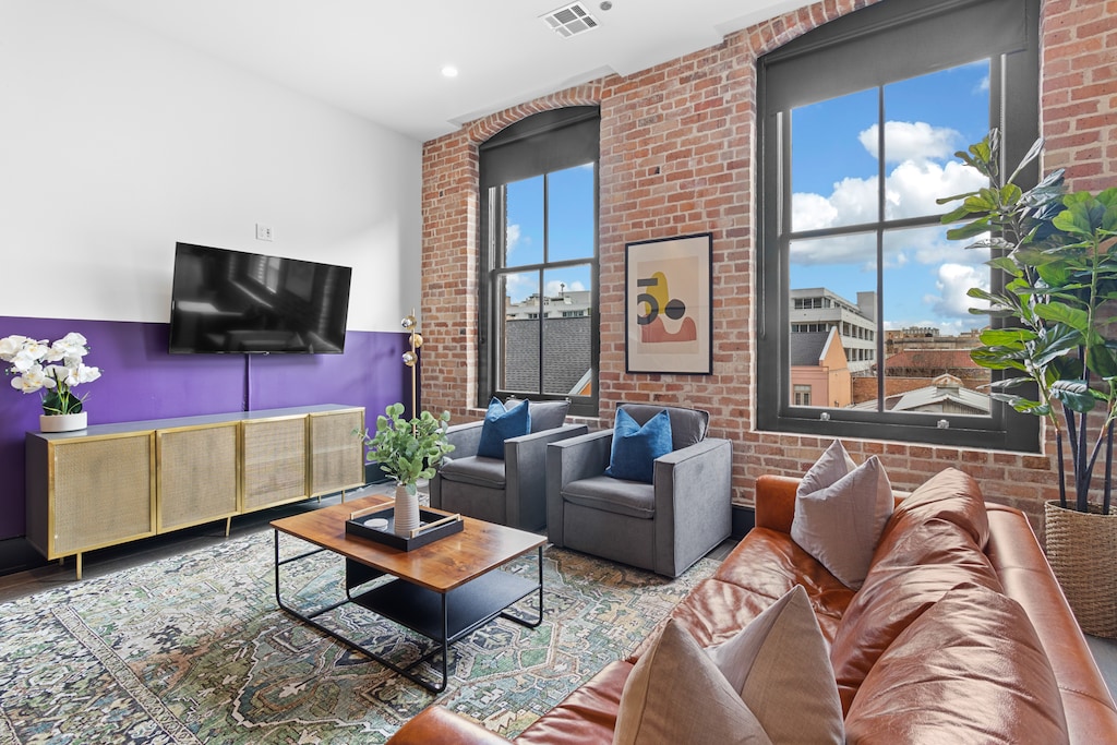 Relax in the living area with a smart TV, stylish seating, and a sleeper sofa for extra guests. Perfect for families or group stays in New Orleans, this inviting space is ideal for movie nights or recharging after a day in the city.