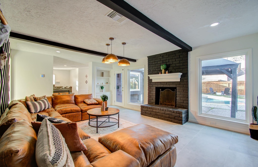 This inviting living room offers the perfect blend of charm and comfort with its rustic décor, a stunning accent wall, and a beautiful view of the backyard. 