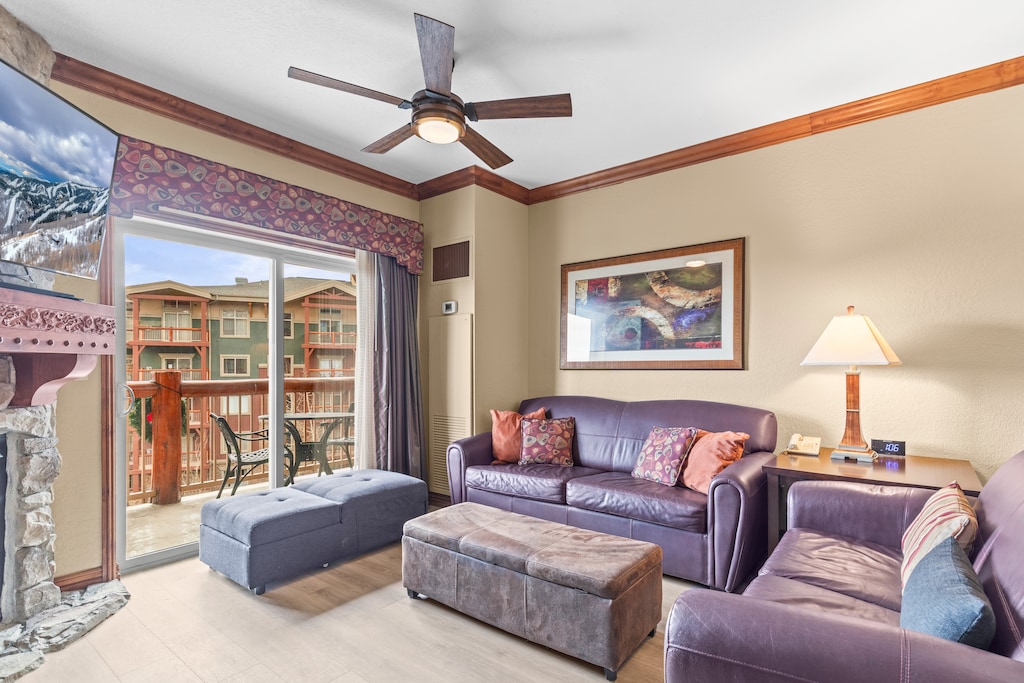 Relax in your comfortable living room with plush leather seating, cozy fireplace, and private balcony access.