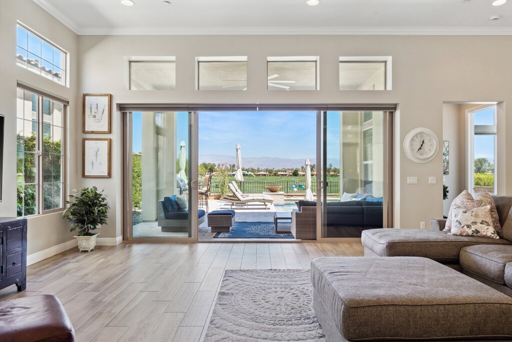 Floor-to-ceiling glass opens to pool and patio—indoor-outdoor living connects every space seamlessly here.
