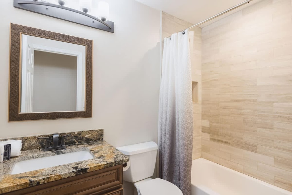 Clean, spacious bathroom with granite counters and storage