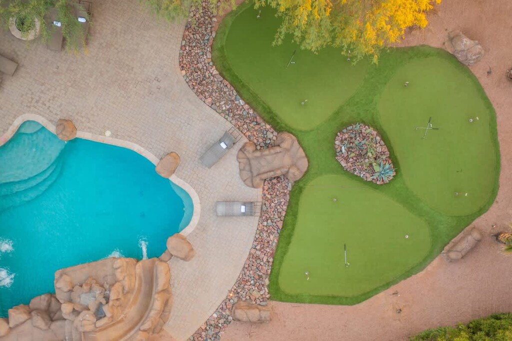 Aerial view of backyard with pool and multiple putting greens