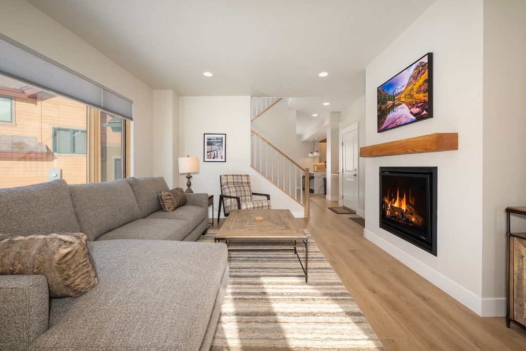 - Spacious living room is anchored by a cozy sectional sofa and large coffee table - Modern fireplace and mounted TV provide warmth and entertainment for your group - Soft lighting and neutral tones invite relaxation in this bright and open space