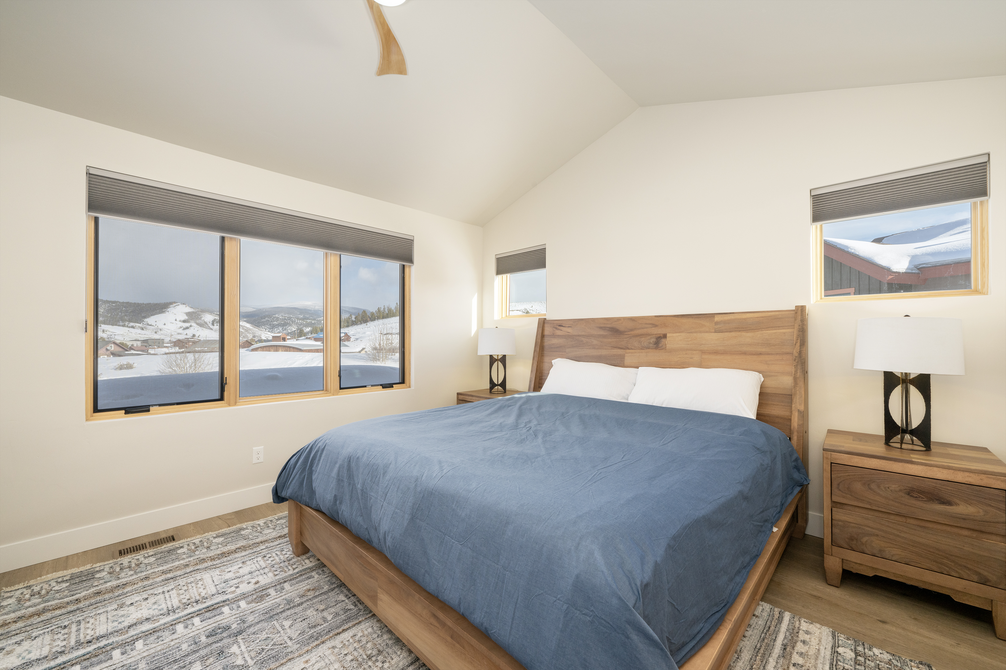 - Retreat to this spacious bedroom featuring a king size bed with wood frame and modern style - Large windows reveal stunning mountain views and fill the space with natural light - Soaring ceilings and cozy accents create a peaceful alpine escape
