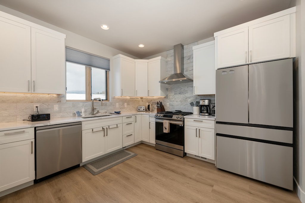 - Pristine kitchen boasts modern white cabinetry, marble backsplash, and essential appliances - Extra counter space and natural light from the window make cooking a delight - Perfectly designed for those who enjoy both functionality and style