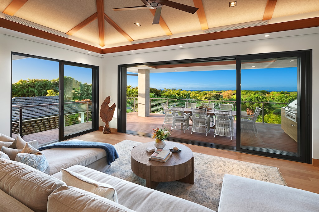 Relax in the cozy living room with expansive glass doors opening to serene outdoor views.