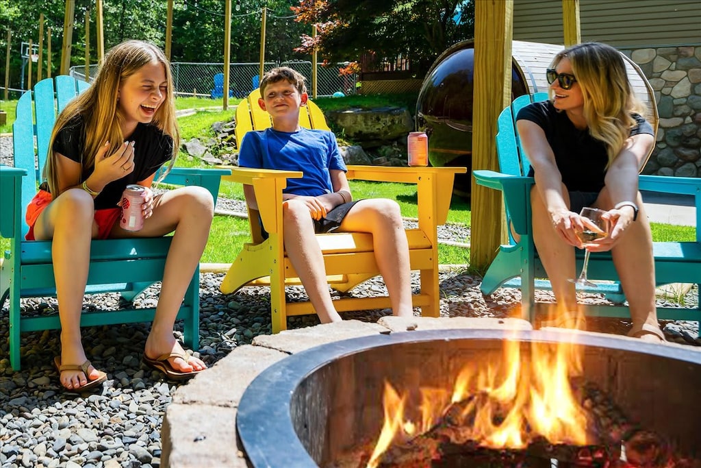 One of our favorite spots at Wooded Retreat in the Poconos is the wood-burning fire pit in the open-air pergola surrounded by 12 premium Adirondack chairs.