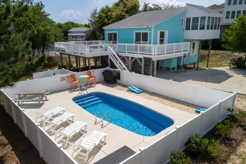 Great outdoor area with a saltwater pool, loungers, grill, and corn hole! 