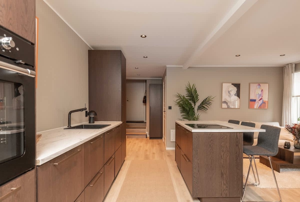  Nyoppusset kjøkken med varm brun tre og en flott kjøkken øy, perfekt  sted for både matlaging og koselige stunder. 