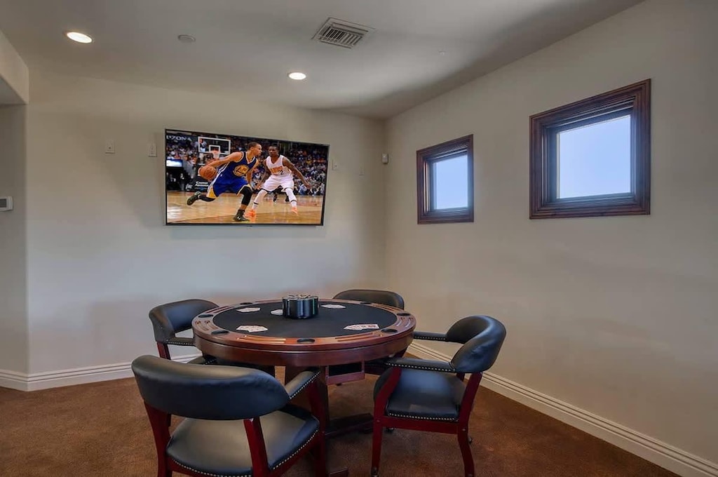 Entertainment game room with comfortable seating and TV