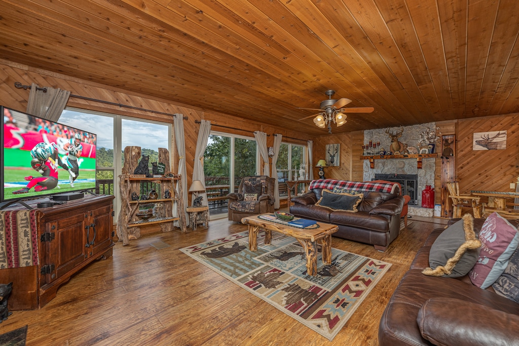 Living room with a fireplace, TV, and large windows at Bearing Views, a 3 bedroom cabin rental located in Pigeon Forge