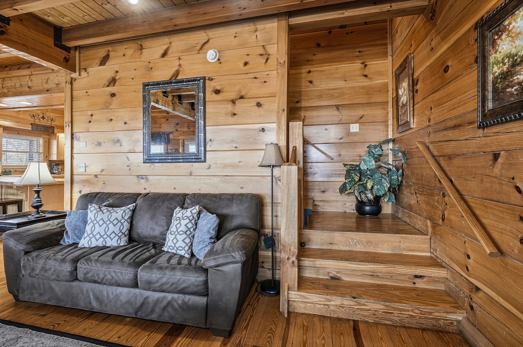 Sink into the plush leather sofa beneath rustic wood beams, where cozy pillows invite you to unwind in this charming cabin retreat.