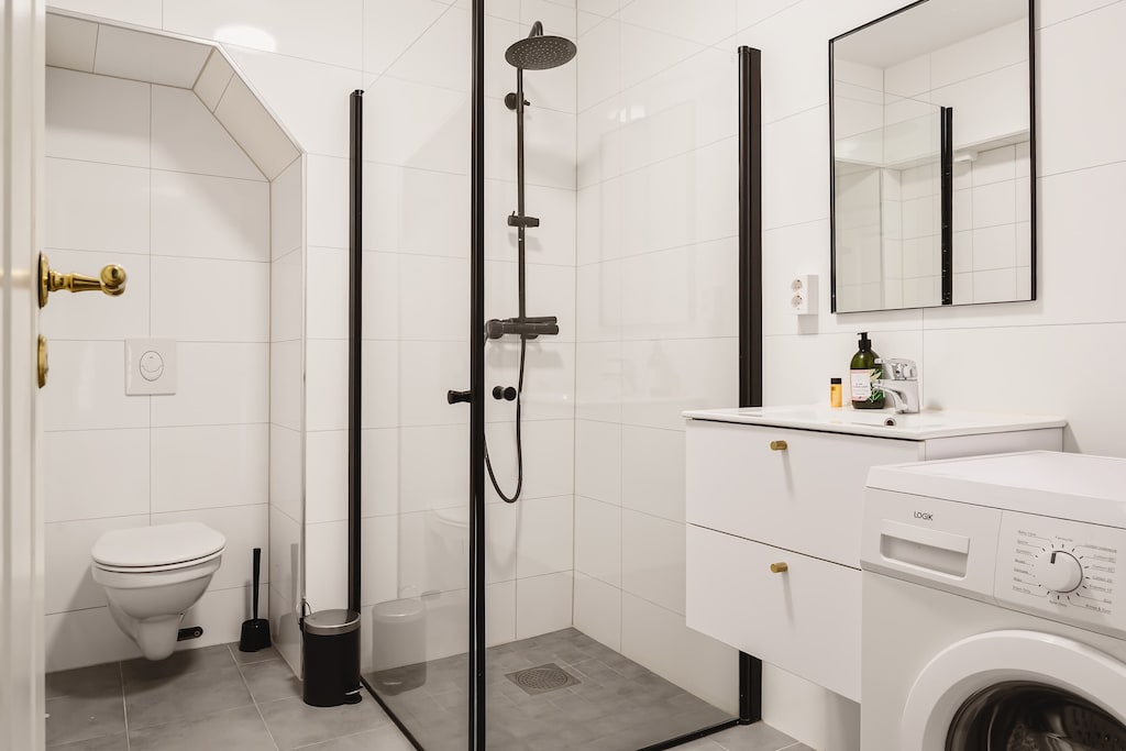 Modern bathroom with walk-in shower, fresh white tiles, and sleek fixtures for comfort and convenience.