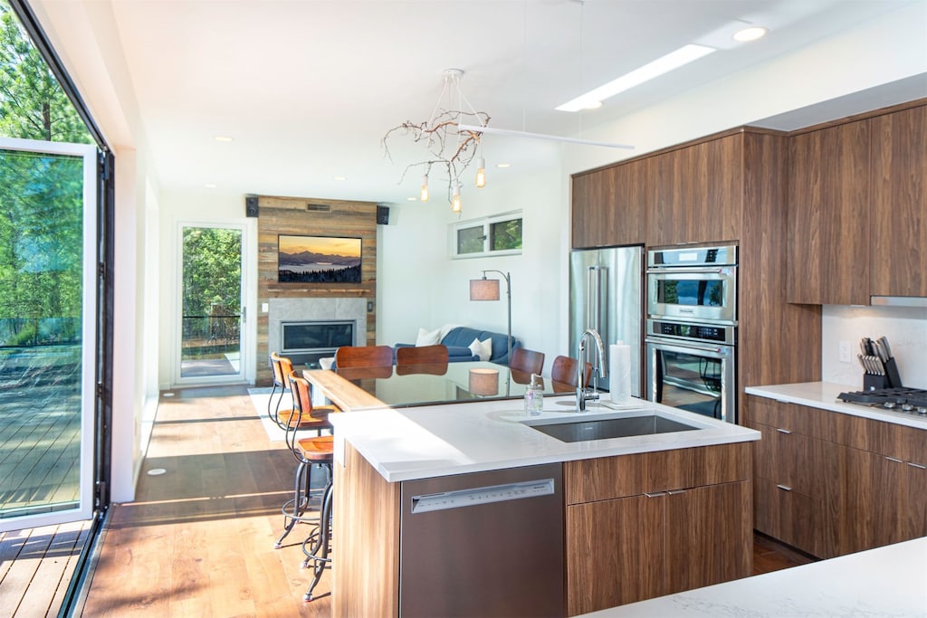 The open concept kitchen, dining & living room is framed by accordion style doors that bring the outdoors within | Main Floor
