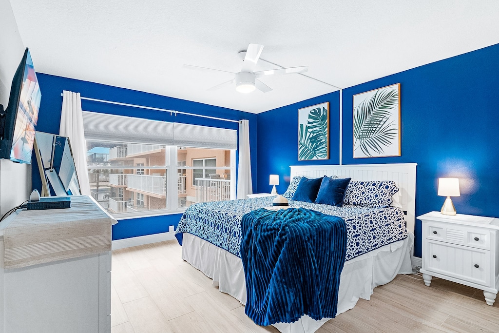 Bright and stylish bedroom with bold blue accents, a comfy king bed, and a balcony view to kickstart your mornings.