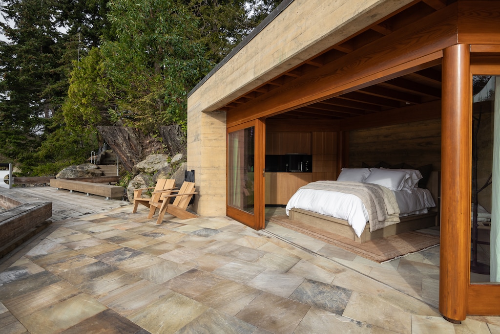 Modern lakeside suite with floor-to-ceiling windows and outdoor access.