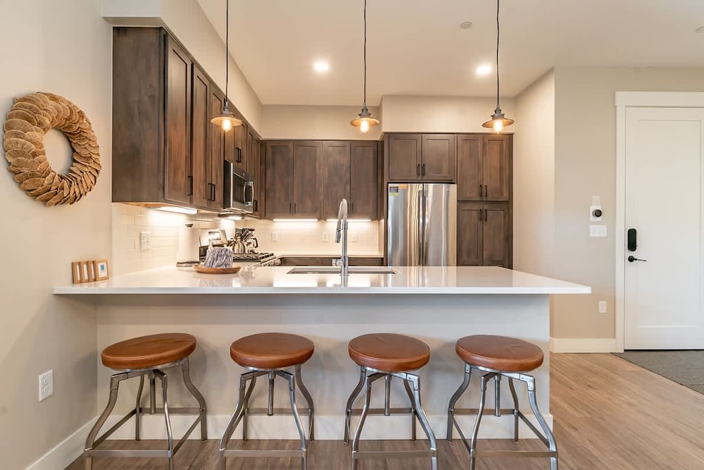Whip up meals in this fully equipped kitchen featuring stainless steel appliances, a spacious island with bar seating, and stylish pendant lighting—great for coffee, snacks, or gathering with friends.