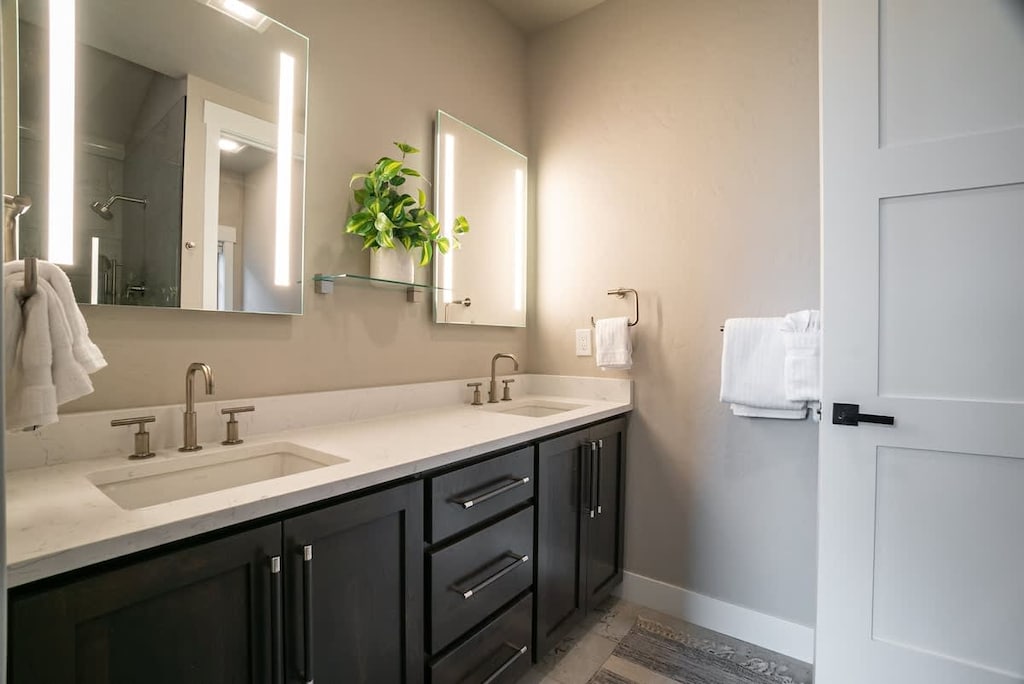 - Elegant double vanity features quartz countertops, rich cabinetry, and plenty of storage
- Backlit mirrors and plush towels enhance the serene ambiance
- Designed for both function and indulgence throughout your stay