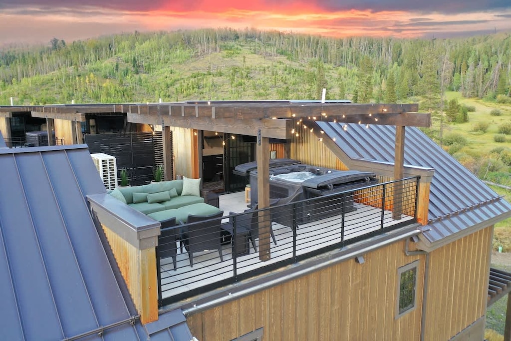 - Soak under the stars in the private rooftop hot tub with panoramic views of the forested hills
- Unwind on the plush sectional with string lights glowing overhead
- Dine al fresco at sunset in this cozy mountain top retreat