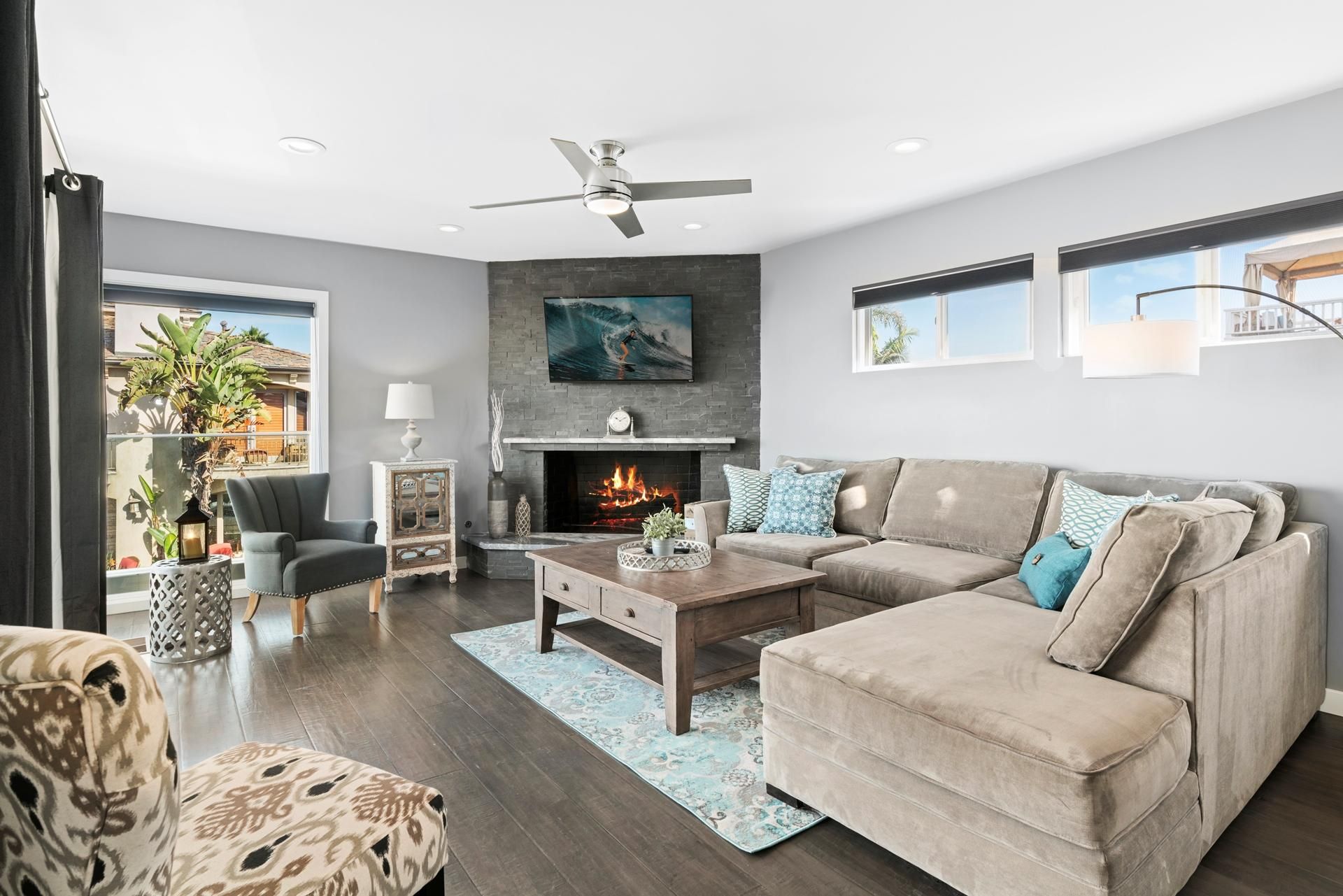 Main upper level living room of front main house, with ocean views, comfy seating, TV, fireplace. Access to front ocean view balcony and outdoor seating.