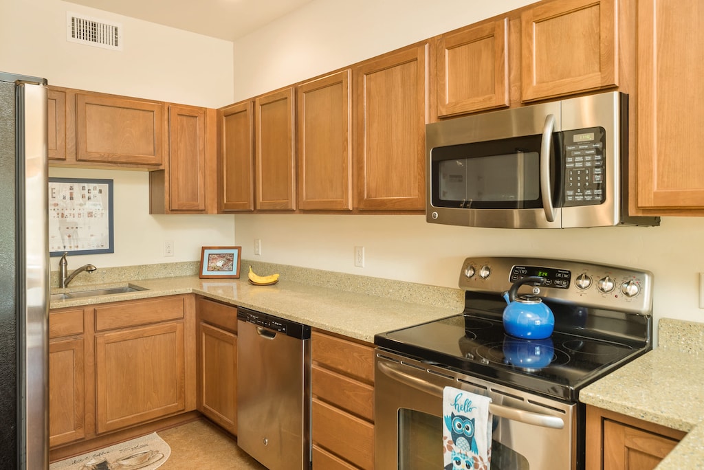Well stocked kitchen with soaps, trash bags, sponge and paper products