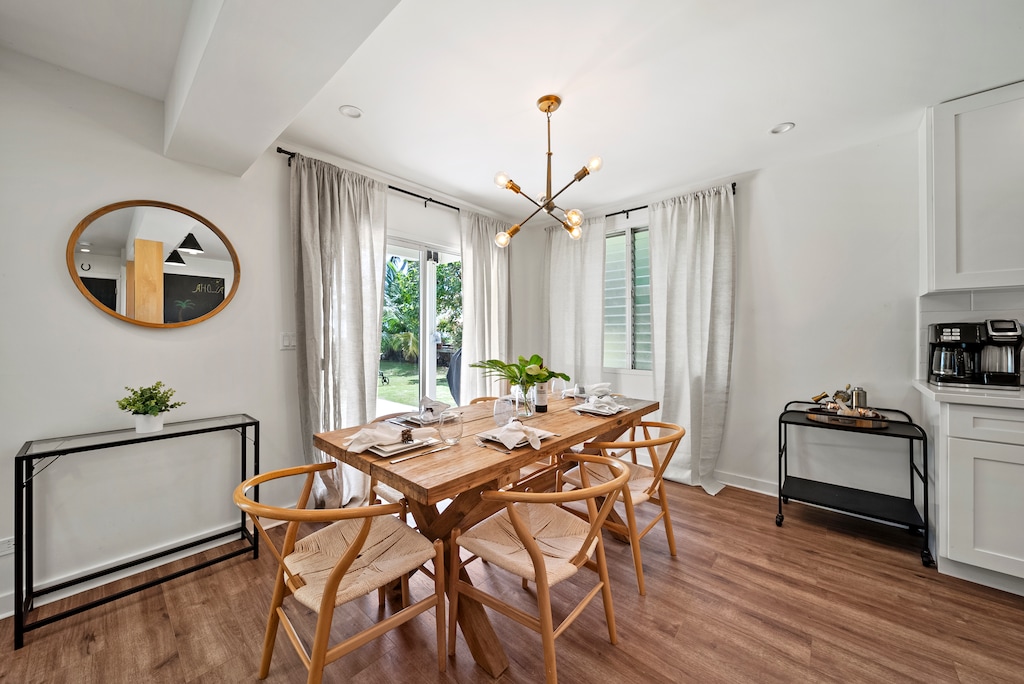 Open-concept dining nook with stylish modern furniture, providing a sunny and intimate spot for leisurely breakfasts or game nights.