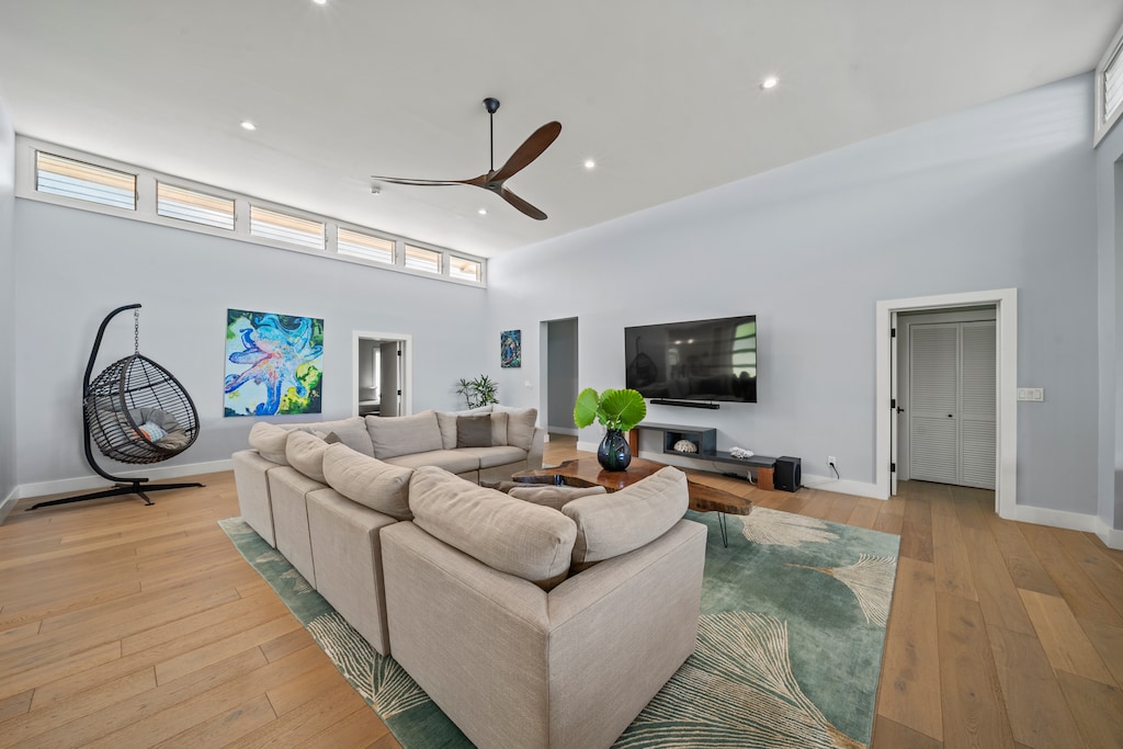 Open-concept living room surrounds plush sofa with clerestory windows and ocean breezes.