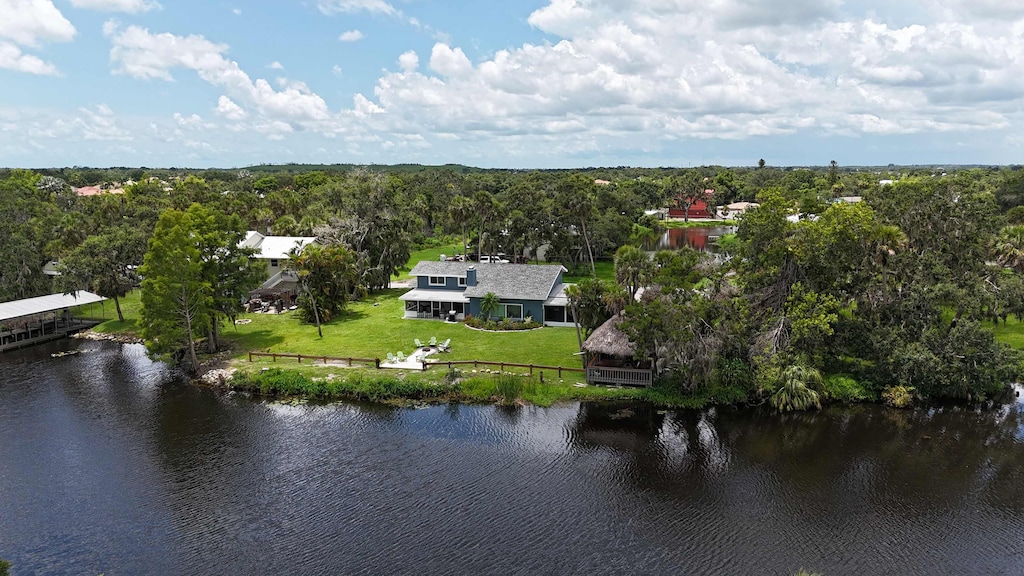 Aerial view showcasing the spacious backyard with a fire pit, tiki hut, and direct river access—an ideal spot for outdoor relaxation.