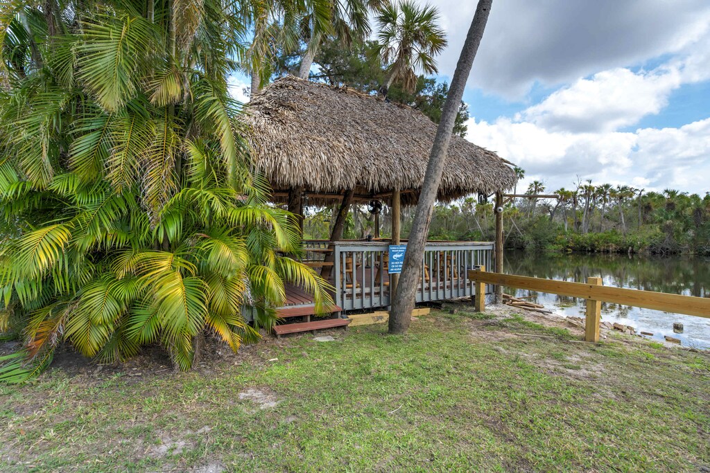 Relax in the shaded tiki hut by the water, the perfect spot to unwind and soak in the peaceful surroundings.