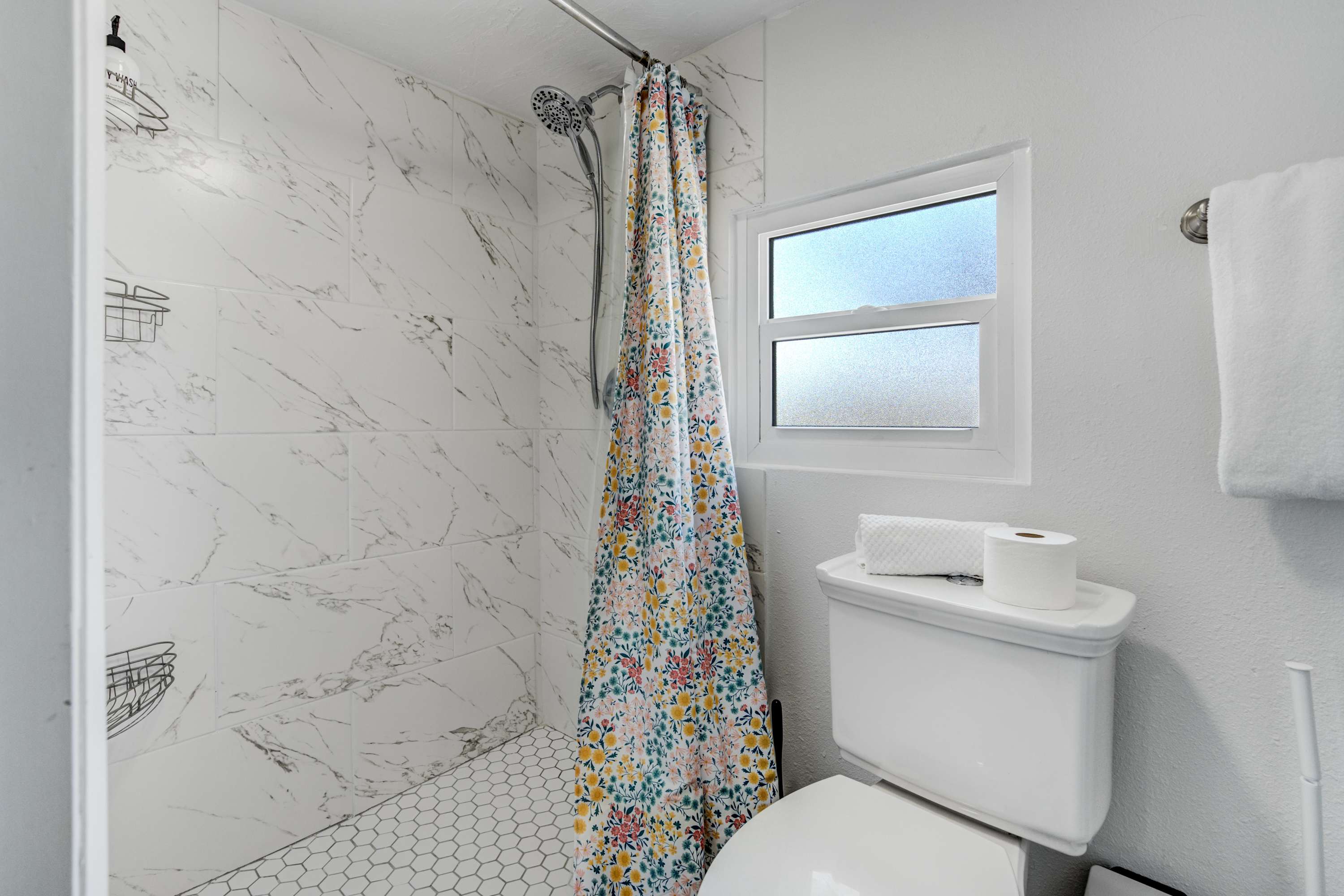 The bathroom features a walk-in shower, fresh towels, and essential toiletries—providing a clean and refreshing space to start your day.
