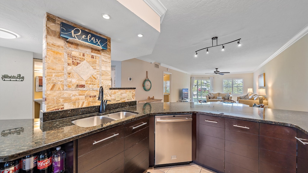 Relax and enjoy the view from the kitchen with its double sink and dishwasher, offering a seamless flow to the sunlit living room and screened lanai for true Siesta Key living.