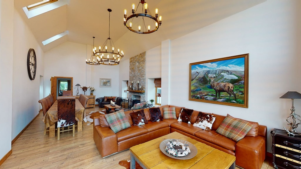 The large lounge with impressive cathedral ceiling, leather couches, dining table and log burner