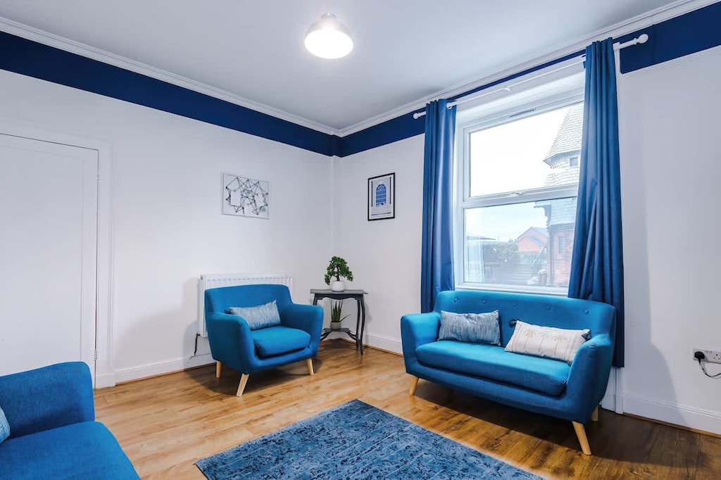 This city centre living room features a smart TV, comfortable sofas, and a selection of games. The space is modern and inviting, perfect for both relaxation and entertainment.