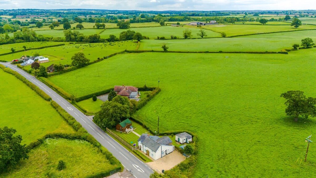 The property benefits from plenty of outdoor space with multiple seating areas and a log cabin at the end of the garden.