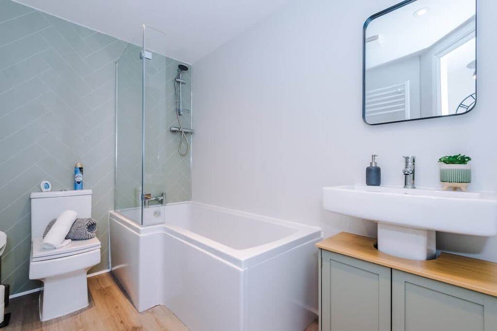 The main bathroom benefits from a toilet, sink and bath with an overhead shower.